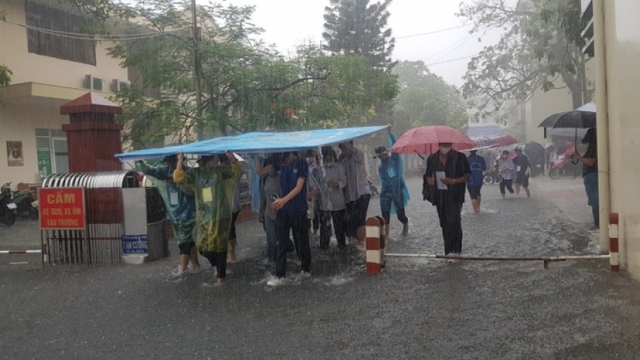 Muôn kiểu đội mưa đưa thí sinh ra khỏi phòng thi