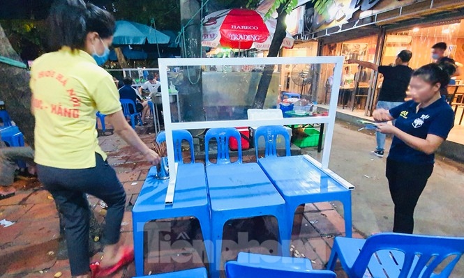 Staff prepare tables with shields in order to follow newly-implemented rules.