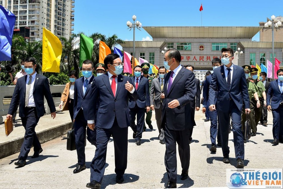 Deputy Prime Minister and Foreign Minister Pham Binh Minh welcomes Chinese Foreign Minister Wang Yi at the boundary line of Bac Luan I bridge (on the Vietnamese side).