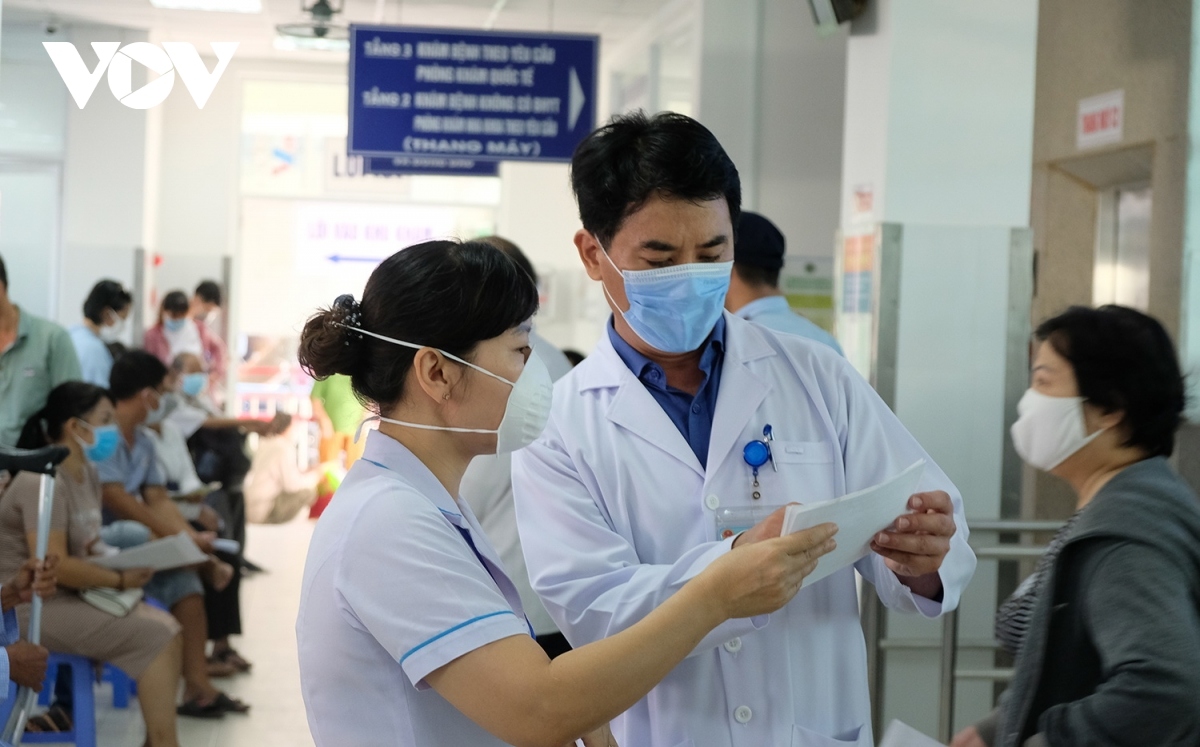 Dr. Le Duc Nhan, director of the Da Nang Hospital (R), directly guides people at the medical examination area. Indeed, the morning of September 15 sees 1,500 patients visit the hospital.