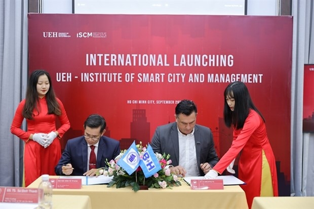 Su Dinh Thanh, Rector of the HCM City University of Economics (left) and a representative of B + H Architects Company sign an agreement for a smart city training programme. (Photo courtesy of the HCM City University of Economics)