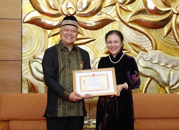 Ambassador Nguyen Phuong Nga (R), President of the Vietnam Union of Friendship Organizations (VUFO), presents the “For peace and friendship among nations” insignia to outgoing Indonesian Ambassador to Vietnam Ibnu Hadi.(Photo: VNA)
