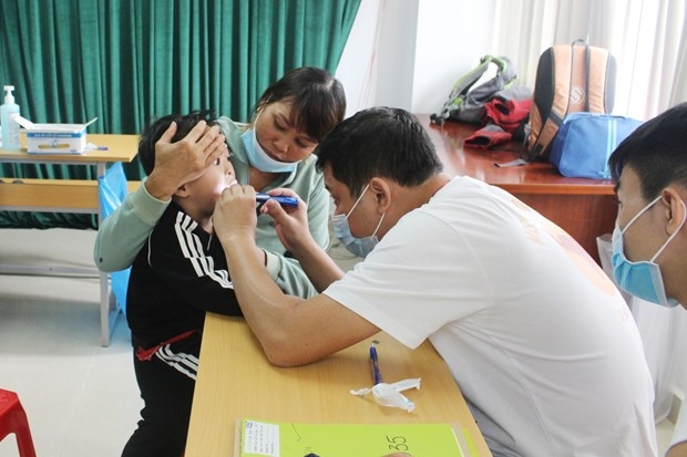 A doctor gives check-up to a child under the cleft lip and palate surgery programme in Dak Lak province.