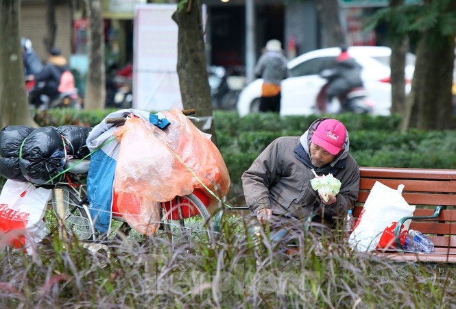 A poor man eats a quick lunch on the banks of Ho Guom, also known as Sword Lake.