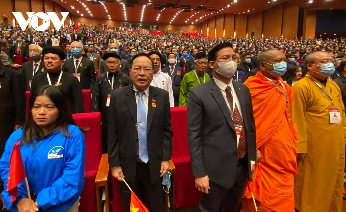 Delegates stand to salute the national flag.