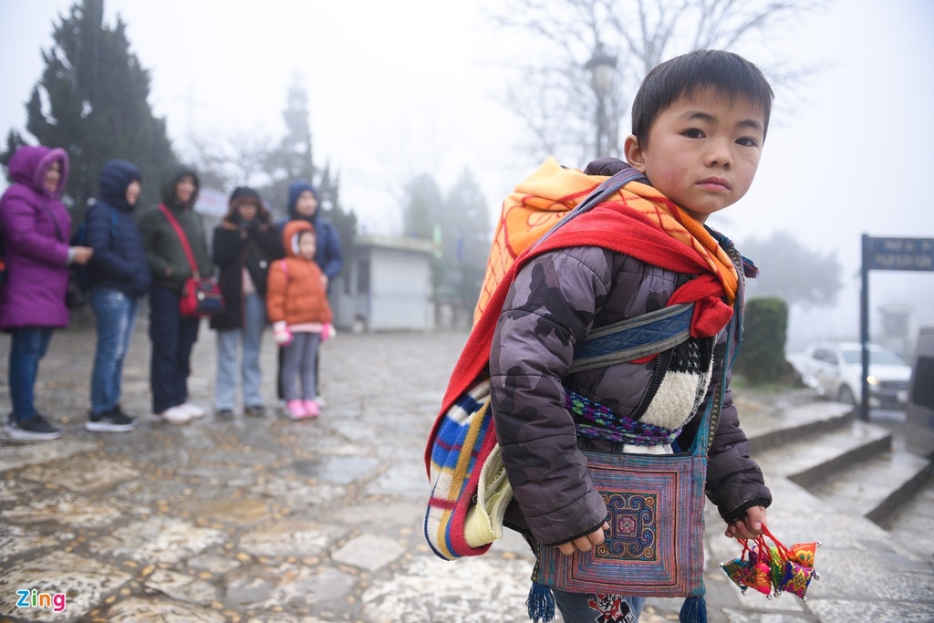 An ethnic H’Mong boy carries his younger brother whilst going about their daily tasks.