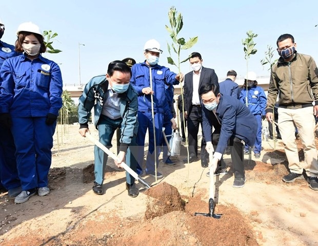 Secretary of the Hanoi Party's Committee Vuong Dinh Hue (right) and Minister of Environment and Natural Resources Tran Hong Ha (left) plant a tree in response to the tree planting festival.