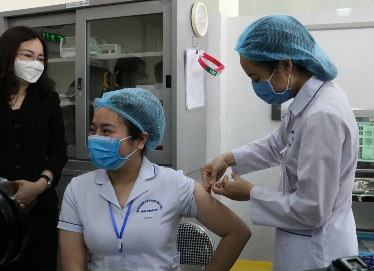 A medical worker is injected with the COVID-19 vaccine