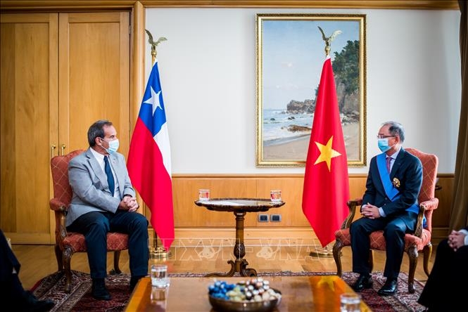 Chilean Foreign Minister Andres Allamand (L) and Vietnamese ambassador Nguyen Ngoc Son exchange views on the sidelindes of the March 25 celebration in Santiago. (Photo: VNA)