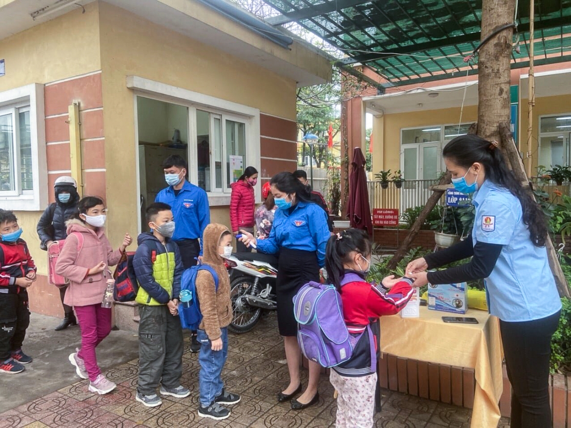 In Hanoi capital, the Youth Union assist a local primary school in measuring the body temperature of arrivals and guiding pupils on how to use hand sanitizer in the fight against the novel coronavirus (COVID-19).