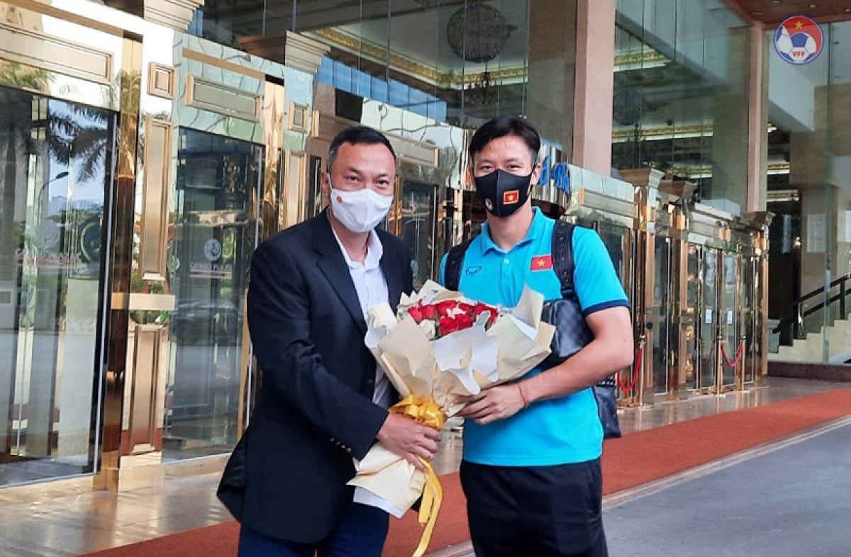 Tuan gives a bouquet of flowers to captain Que Ngoc Hai who represents the national team, wishing them luck in completing their task in the UAE.