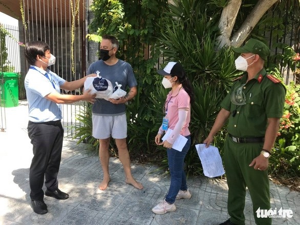 Cao Dinh Hai - Chairman of the People's Committee of Nai Hien Dong ward, Son Tra district, presents food to a foreigner in the area. (Photo: tuoitreonline)