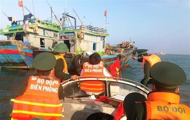 Border guards in Quang Binh province examine a fishing boat and disseminate legal regulations to fishermen.
