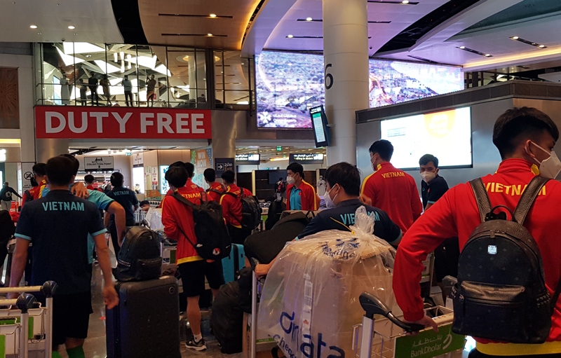 The players carry their hand luggage to the boarding gate.