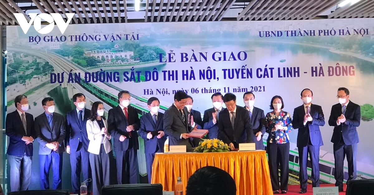 Deputy Minister of Transport Nguyen Ngoc Dong and Hanoi's Vice Mayor Duong Duc Tuan sign a document to hand over the metrol line to Hanoi for commerical operation.