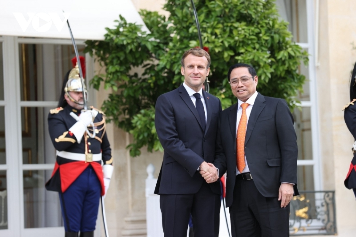 President Emmanuel Macron (L) welcomes Prime Minister Pham Minh Chinh in Paris.