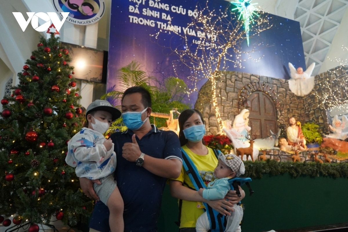 A family pose for a photo in front of a nativity scene placed at Ky Dong Church.