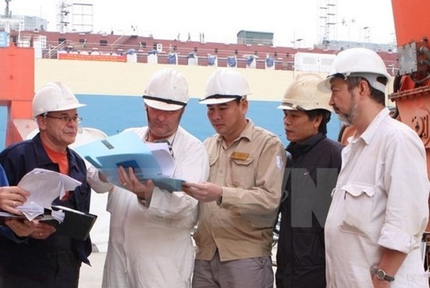 Foreign and Vietnamese workers at a construction site.