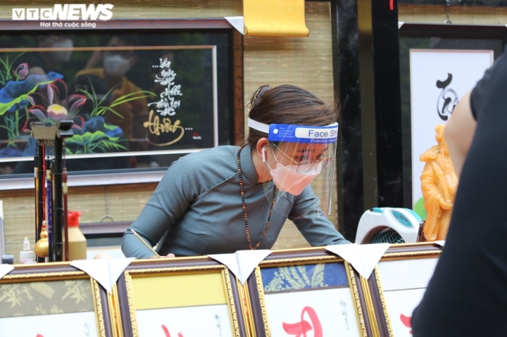 Buying calligraphic works is believed to bring good luck and prosperity ahead of a new lunar year. Calligraphers don face mask and follow the Health Ministry’s 5K message on COVID-19 prevention measures.