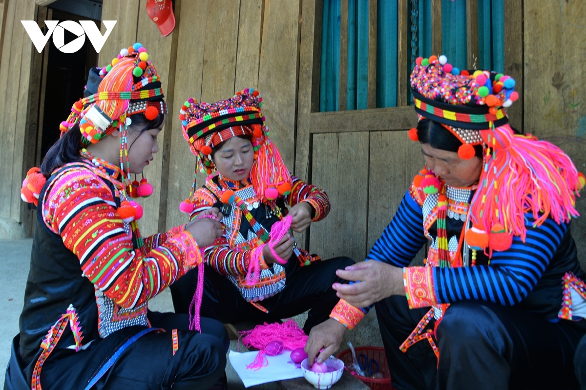 Women prepare balls for folk games, including nem con, which involves throwing a ball through a ring for good luck, during the ritual.
