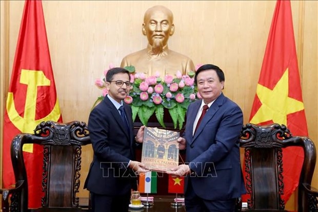 Politburo member, President of the Ho Chi Minh National Academy of Politics and Chairman of the Central Theory Council Nguyen Xuan Thang (R) receives a gift from Indian Ambassador Pranay Verma.