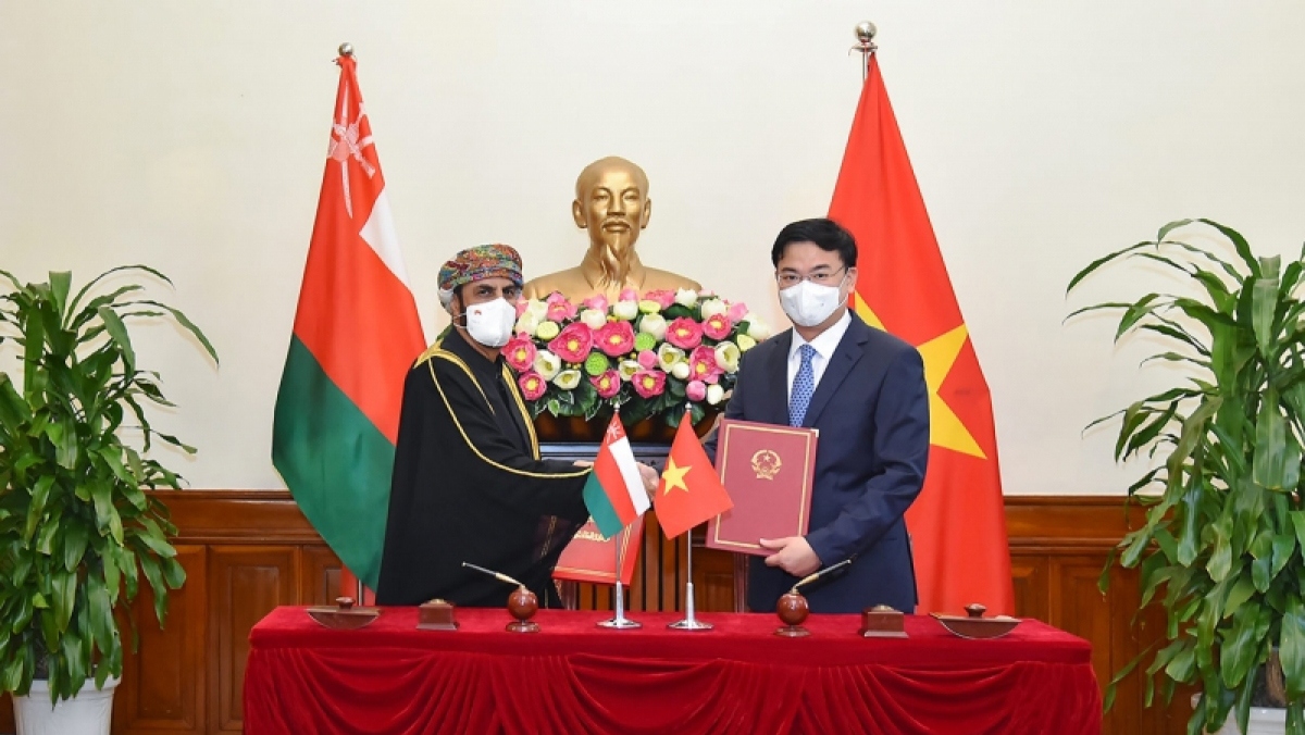 Vietnamese Deputy Minister of Foreign Affairs Pham Quang Hieu and Omani Ambassador Saleh Mohamed Ahmed Al Sagri exchange notes after the signing ceremony..