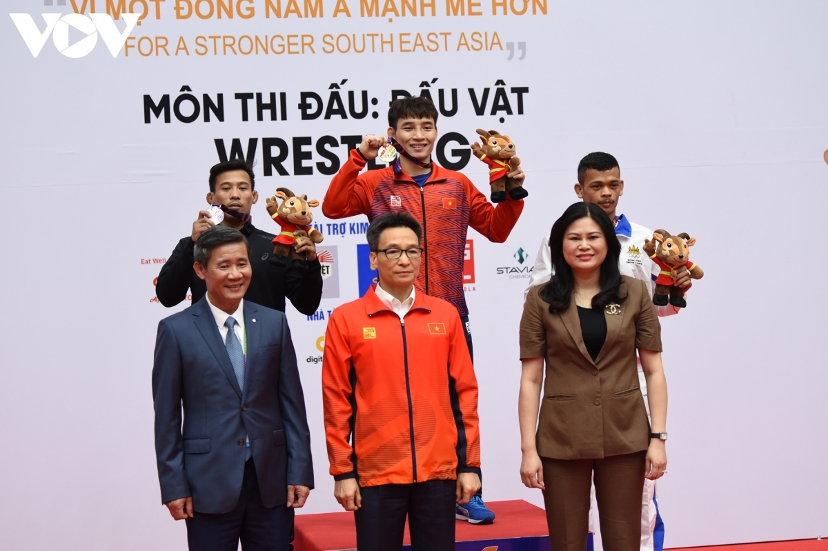 Deputy Prime Minister Vu Duc Dam hands over medals to the winners in the wrestling event.