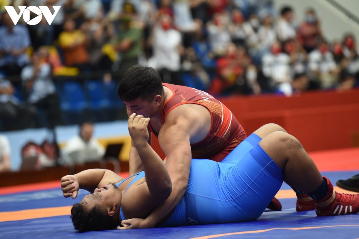 Ngo Van Lam (in red jersey) grabs a silver medal after defeating a Laotian rival in the 125kg category.