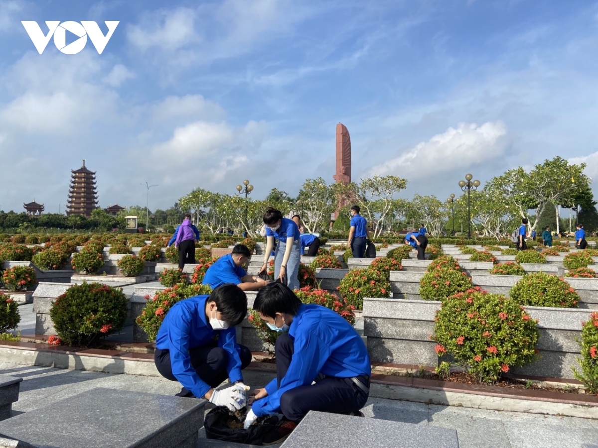 Volunteers in Vinh Long city spend time on cleaning the martyrs’ grave as they prepare for a candle-lighting ceremony on the night of July 26.