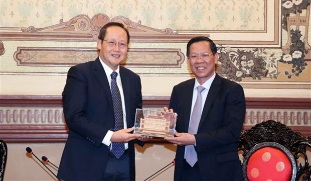 Phan Van Mai, Chairman of the Ho Chi Minh City People's Committee (right) hands over a souvenir to Tan See Leng, Singapore’s Minister for Manpower and Second Minister for Trade and Industry. (Photo: VNA)