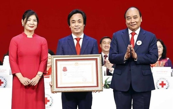President Nguyen Xuan Phuc (R) presents a third-class Labour Order to the Humanitarian TV Centre. (Photo: VNA)