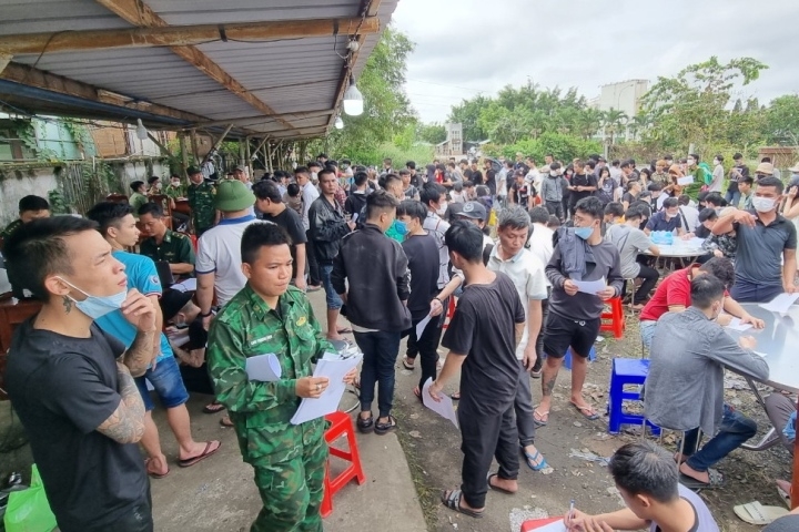 Border guards proceed the entry of over 800 Vietnamese workers returning Vietnam from Cambodia via Moc Bai International Border Gate (Photo: Tay Ninh Newspaper)