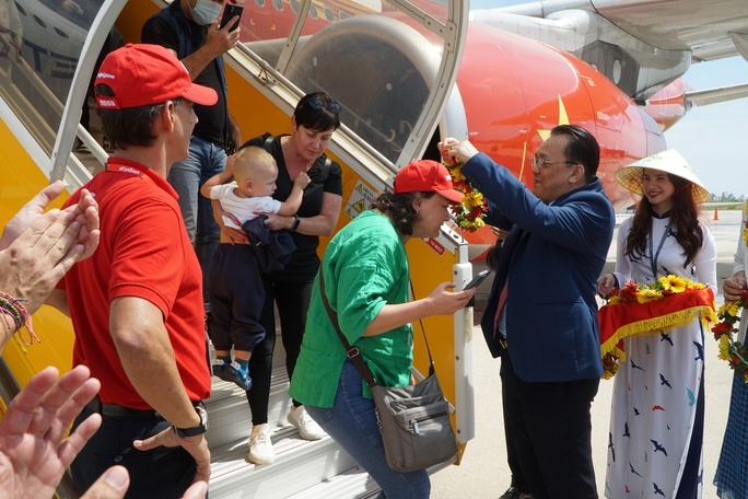 Le Huu Hoang, vice chairman of the Khanh Hoa provincial People’s Committee, offers flowers to tourists arriving in the nation from Kazakhstan.