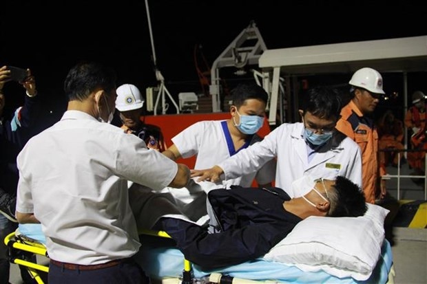 Health workers provide check-ups for the sick sailor before brought him ashore for further treatment.