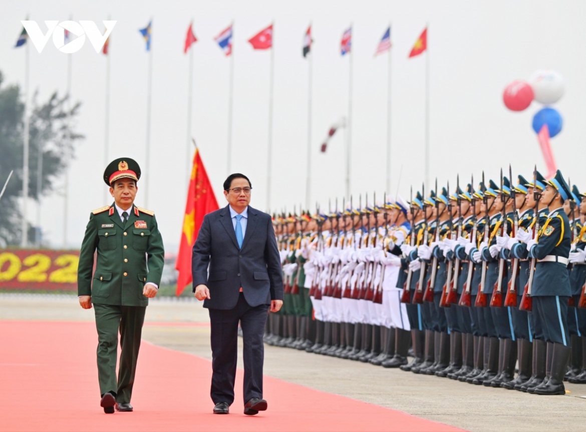Defence Minister Phan Van Giang invites the PM to review the guard of honour at the event.