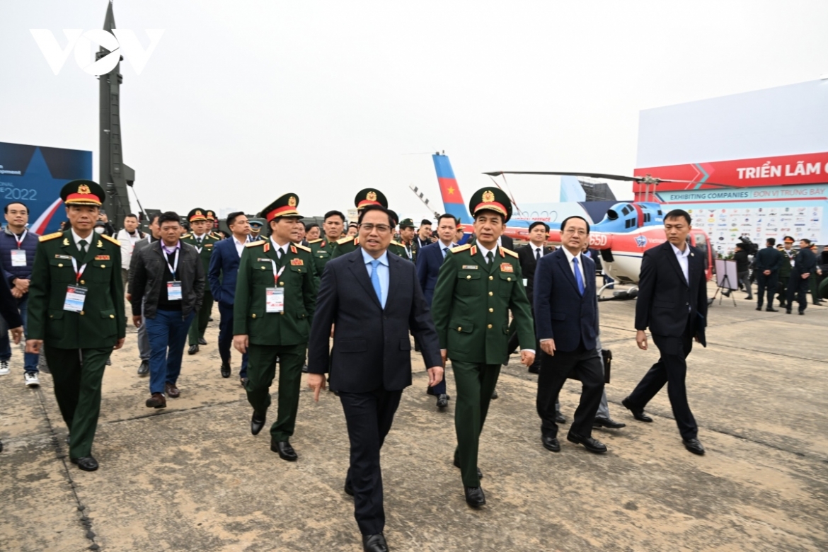 The Vietnamese leader views the military weapons on show at the function.