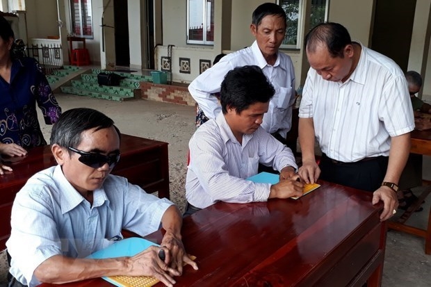 Visually impaired people are assisted to learn Braille.
