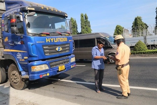 Police check a driver's papers on Highway No 1 in Chau Thanh district, Tien Giang province.