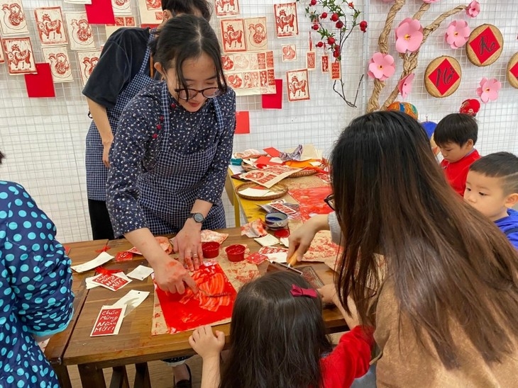 Parents and children participate in woodblock printing activities.