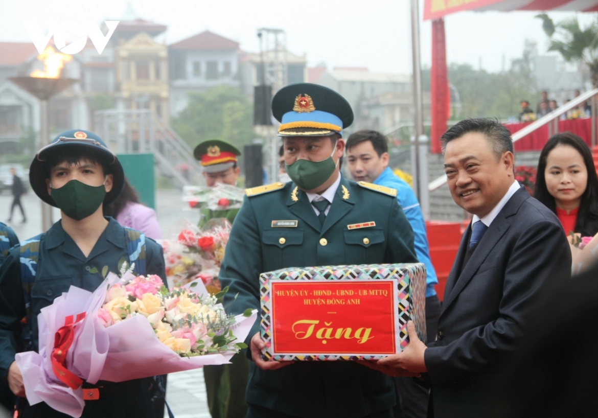 Tran Sy Thanh, head of the Hanoi administration (R), encourages newly-recruited soldiers of Dong Anh district before joining the military units.
