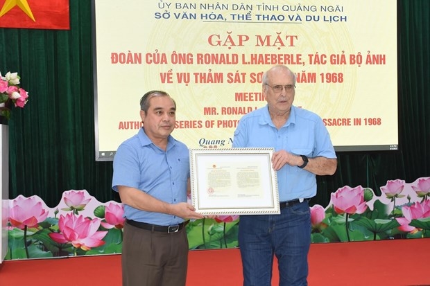 A leader of Quang Ngai province presents a thank-you letter to Ronald L. Haeberle, who took pictures of the Son My massacre on March 16, 1968, on March 8.