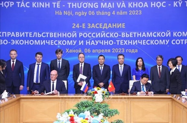 Deputy Prime Minister Tran Hong Ha (R) and his Russian counterpart Dmitry Chernyshenko sign the minutes of the meeting (Photo: VNA)