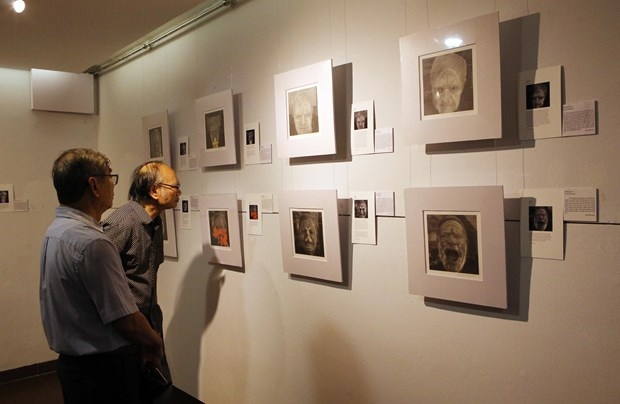 Visitors look at a painting at the exhibition in Da Nang.
