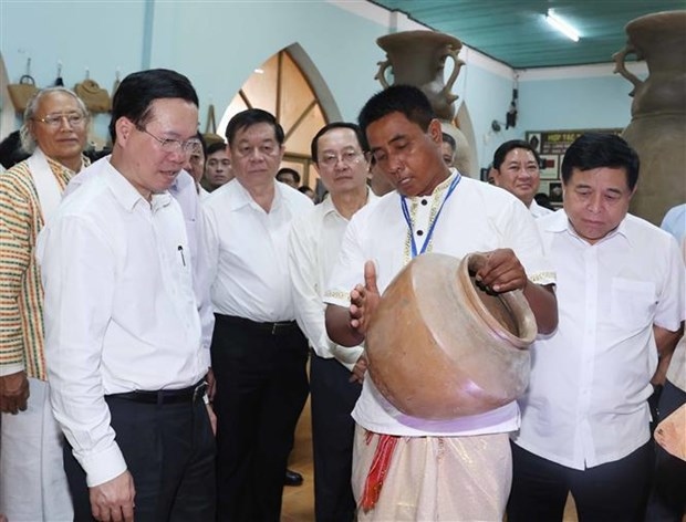 President Vo Van Thuong (left) visits an exhibition hall of pottery products in Bau Truc village on June 15