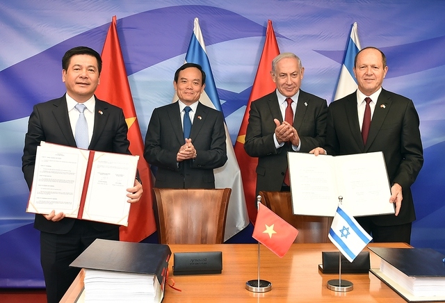 Israeli Prime Minister Benjamin Netanyahu and Vietnamese Deputy Prime Minister Tran Luu Quang (row behind) witness the signing of the VIFTA. (Photo: VGP)