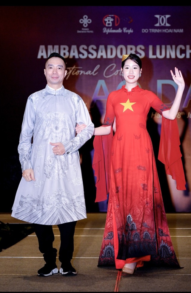 Fashion designer Do Trinh Hoai Nam (L) presents his latest Ao Dai collection inspired by the numerous national flags and heritages of many countries and territories around the world.