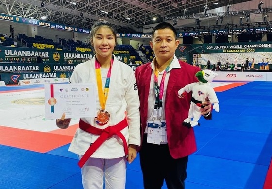 Dang Thi Huyen (left) and her coach pose with the world jujitsu championship bronze medal. VNS Photo Tien Bui