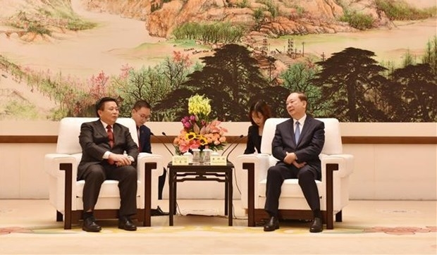 Politburo member Nguyen Xuan Thang (L) meets with Politburo member Huang Kunming.