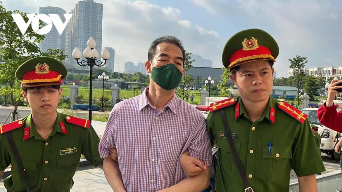 To Anh Dung, former deputy Minister of Foreign Affairs, is escorted to the courtroom in Hanoi on July 11. He has been charged with receiving bribes totalling VND21 billion.