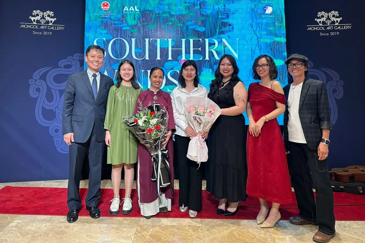 Vietnamese Ambassador to Mongolia Doan Khanh Tam (firsts from left) and artists pose for a group photo at the exhibition.